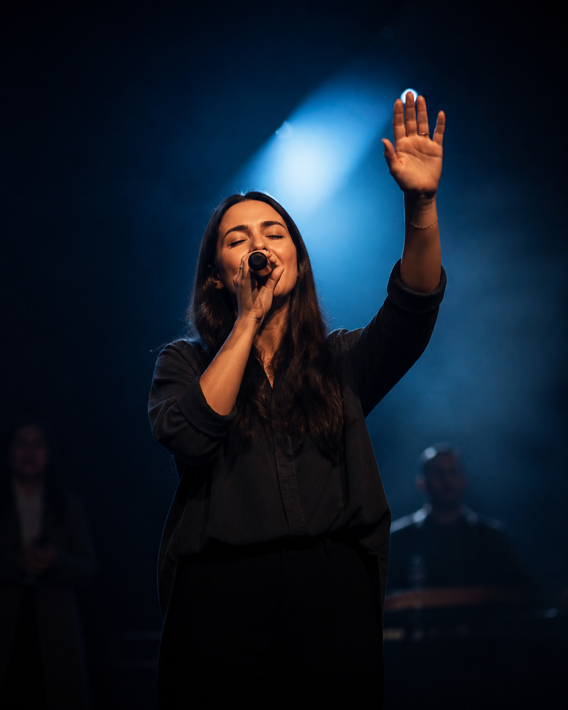 Female worship leader singing on stage